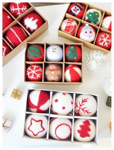 Detail shot of six assorted handmade wool felt Christmas balls in a gift box