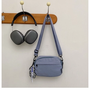 Détail du sac à bandoulière en nylon bleu avec tissu étanche et breloque lapin à carreaux