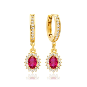 Detail of 925 silver gold earrings featuring oval red gemstones and halo of white zircons