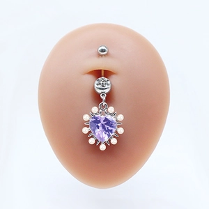 Heart-shaped belly button ring featuring purple gem and white pearl accents on model