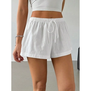 Detail of high-waisted white casual shorts with elastic drawstring and textured fabric