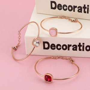Set di tre bracciali geometrici in oro rosa con zirconi quadrati e chiusura a moschettone