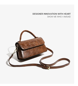 Dettaglio borsa in pelle marrone vintage con fibbie dorate e tracolla regolabile in oro