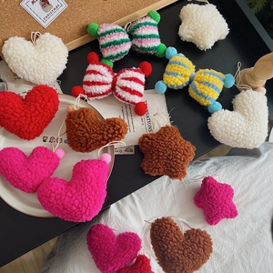 Close-up of plush lamb wool heart and star ornaments with soft texture and hanging loops