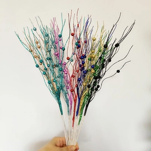 Close-up of glitter-coated berry stems in multiple colors for festive tree decoration
