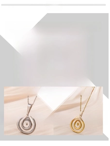 Close-up of modern 18K plated stainless steel swirl pendants in gold and silver