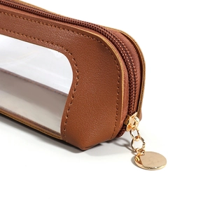 Close-up of brown leather pencil case featuring a gold zipper and clear PVC window