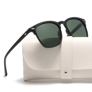 Detail of polarized sunglasses with silver rivets and cream faux leather case
