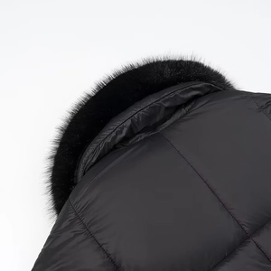 Dettaglio del parka nero con colletto in pelliccia sintetica e tessuto dalla trama liscia