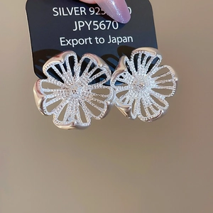 Makroaufnahme von 925er Silber Ohrsteckern in hohler Blumenform mit poliertem Finish
