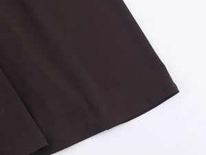 Close-up of high-quality stitching and dark brown fabric hem on the halter chain dress