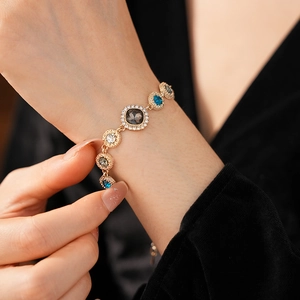 Macro shot of a vintage gold bracelet featuring colorful crystals on a person's wrist