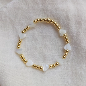 18K gold plated beaded bracelet with natural shell heart charms on white fabric