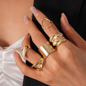 Detail view of 5-piece gold irregular geometric rings worn for high-end fashion styling