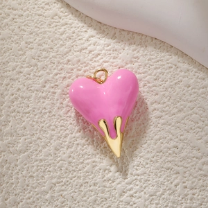 Detail of pink heart pendant with gold accents and zircon inlay for jewelry making