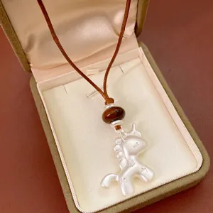 Collier minimaliste licorne argentée avec détails d'étoiles sur cordon tissé marron
