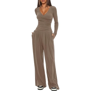 Detail of V-neck crossover pleated top and matching high-waist wide-leg trousers