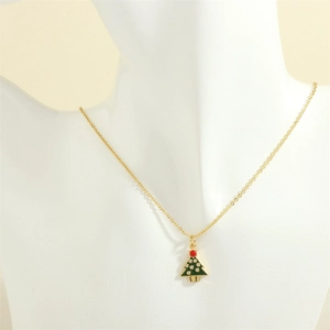 Detailed view of a gold Christmas tree necklace with green enamel and zircon accents