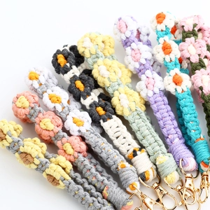 Detail of colorful hand-woven daisy charms with gold metal lobster clasps for phones