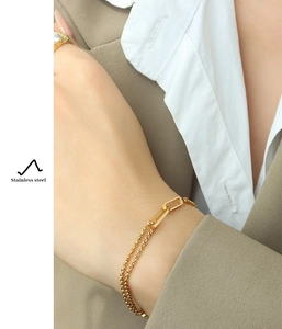 Detail of a double-layered 18K gold-plated stainless steel chain bracelet on wrist