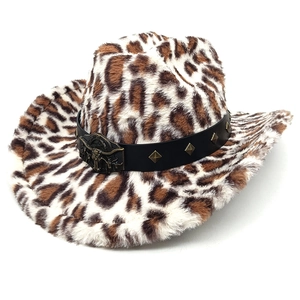 Détail du chapeau de cowboy léopard avec bande en cuir cloutée et tête de taureau en métal