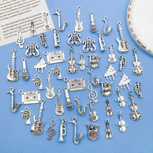 Flat lay of silver music charms like guitars and pianos on a blue background