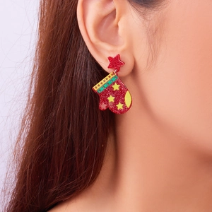 Close-up of red glitter Christmas glove acrylic earring with star stud on model ear