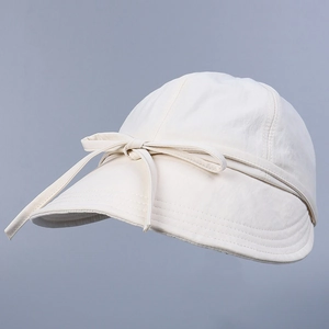 Close-up of cream nylon sun hat with reinforced stitching and decorative ribbon bow
