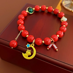 Vue détaillée d'un bracelet de perles rouges avec dragon du zodiaque doré et pendentifs