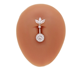 Détail d'un piercing de nombril en argent avec zircon en cœur sur un modèle en silicone