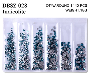 Macro detail of mixed size Indicolite flatback rhinestones in 6-grid organizer box