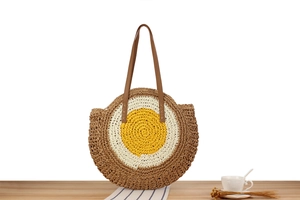 Macro detail of the round straw woven bag featuring a unique egg-inspired design