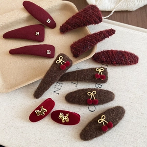 Detailed view of autumn winter plush hair clips in burgundy and brown textured fabrics