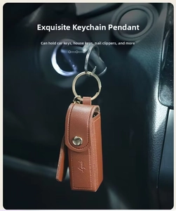 Brown litchi leather mini lipstick bag with gold snap button hanging on car ignition key