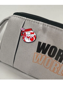 Detail of cartoon cat enamel pin with 'Full of Love' jar design on a canvas bag