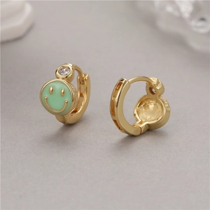 Close-up of gold smile earrings with green enamel and cubic zirconia detail