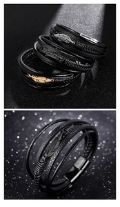 Close-up of multilayer black leather braided bracelets with gold and silver feather charms