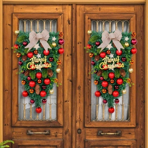 Christmas teardrop swag with red and gold ornaments and Merry Christmas sign on wood doors
