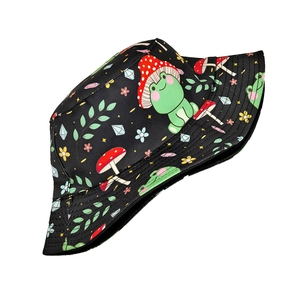 Close-up of vibrant cartoon frog and mushroom print on black cotton bucket hat fabric