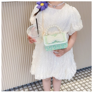 Détail du sac à main vert en tweed pour enfants avec anse en perles et joli nœud