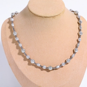 Detailed view of baroque pearl necklace with grey hematite beads on a beige jewelry bust