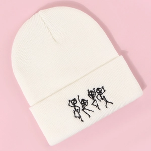Détail du bonnet en maille blanche avec broderie de squelette dansant sur fond rose clair