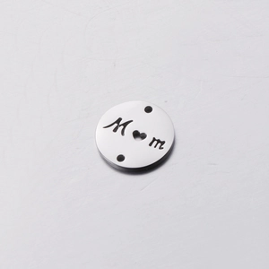 Macro detail of stainless steel round MOM charm with heart cut-out and dual connection holes