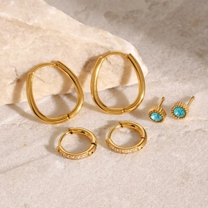 Three-piece gold-plated earring set featuring oval hoops and blue zircon studs