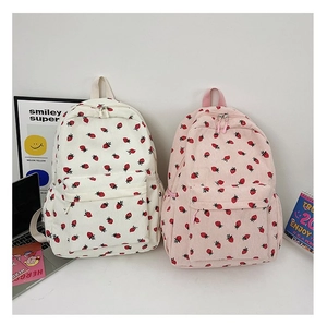 Detail of strawberry print corduroy backpacks in pink and white for school students