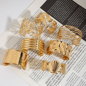 Primo piano di ampi bracciali dorati con texture su sfondo di giornale d'epoca