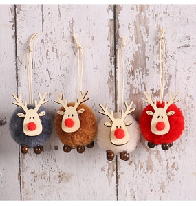 Close-up of four colorful plush reindeer ornaments with wooden details on white wood