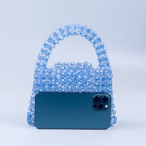 Handmade light blue beaded acrylic trapezoid handbag shown with a smartphone for scale