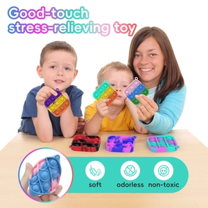 Close-up of soft non-toxic rainbow silicone pop-it keychain held by a happy child