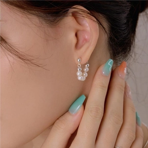 Detailed view of elegant silver ear cuff with alternating pearls and metallic beads